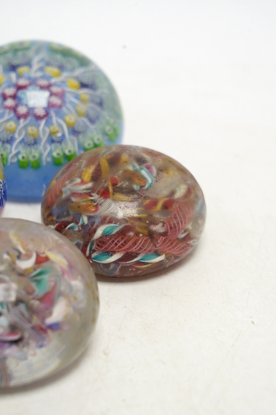 Two Perthshire millefiori glass paperweights and two scrambled glass paperweights, largest 7cm wide. Condition - fair